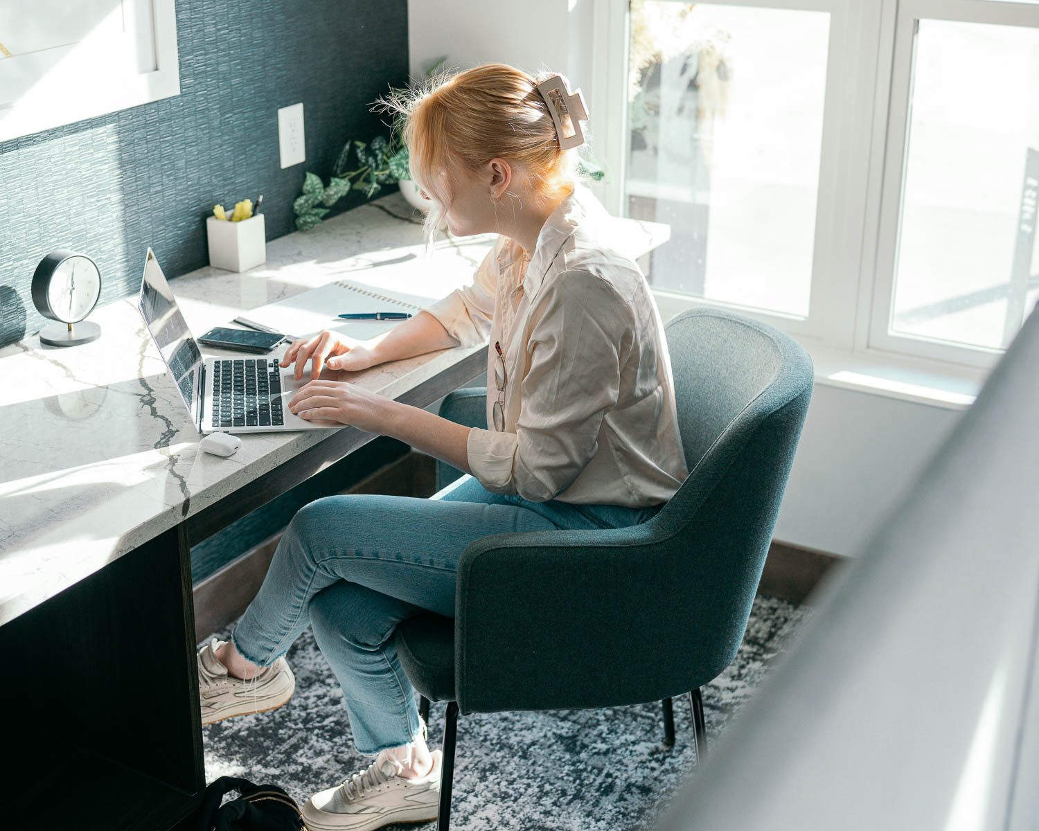 Resident working on a laptop at a desk by the window