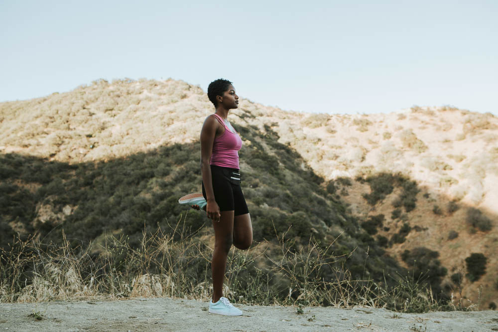 Runner stretching on a hillside trail near Albuquerque