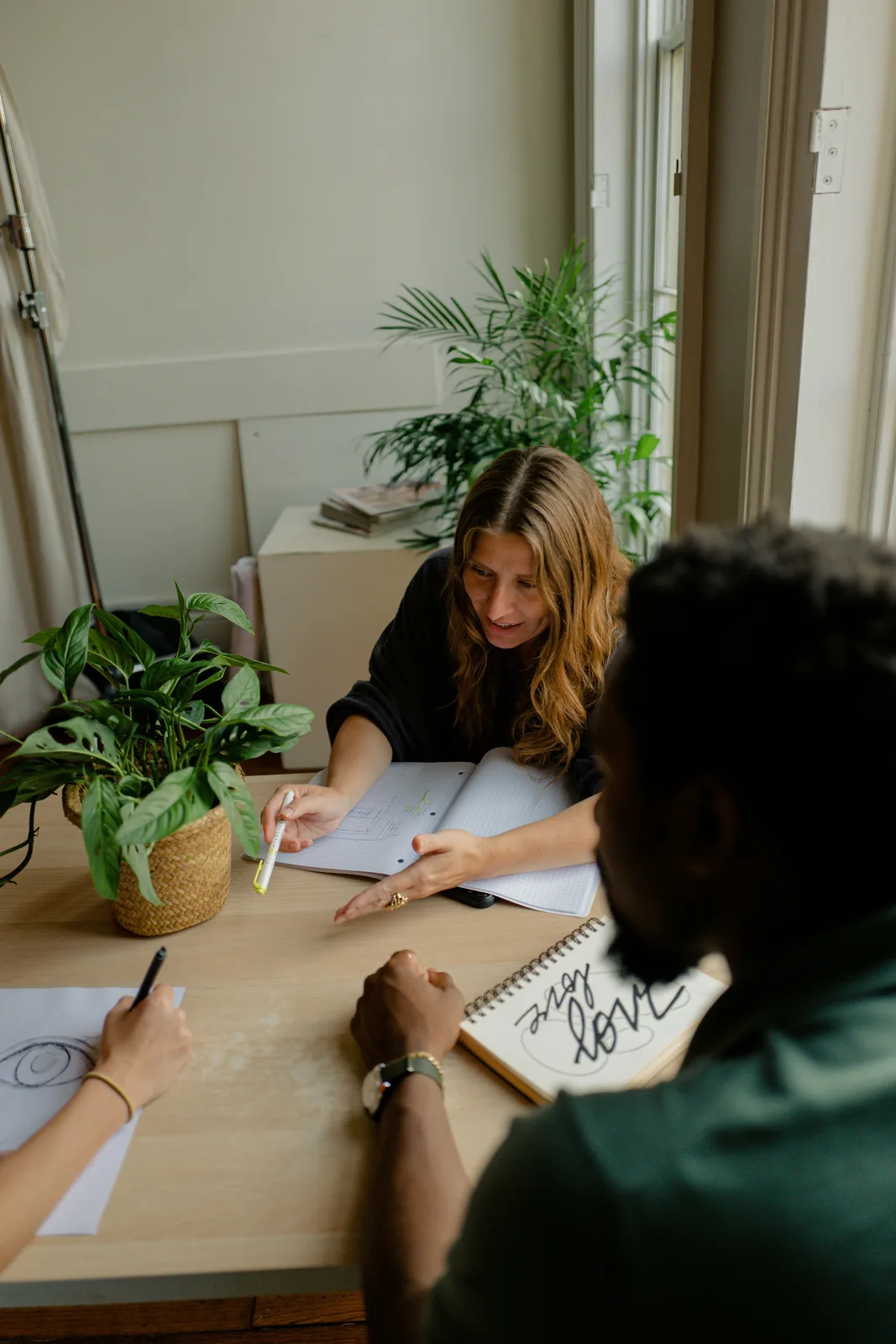 Two people working together at a table in a sunny co-working space