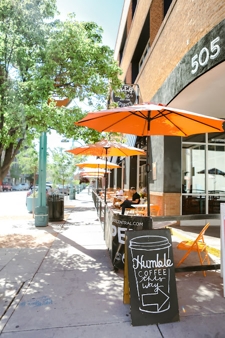 Orange umbrellas over sidewalk patio seating at 505 Central Food Hall